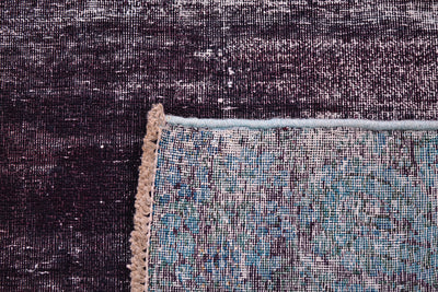 Reverse of vintage hallway runner rug showing back of rug and knots and cotton warp and wefts.  Low pile-zero pile field with deep inky aubergine main field colour.