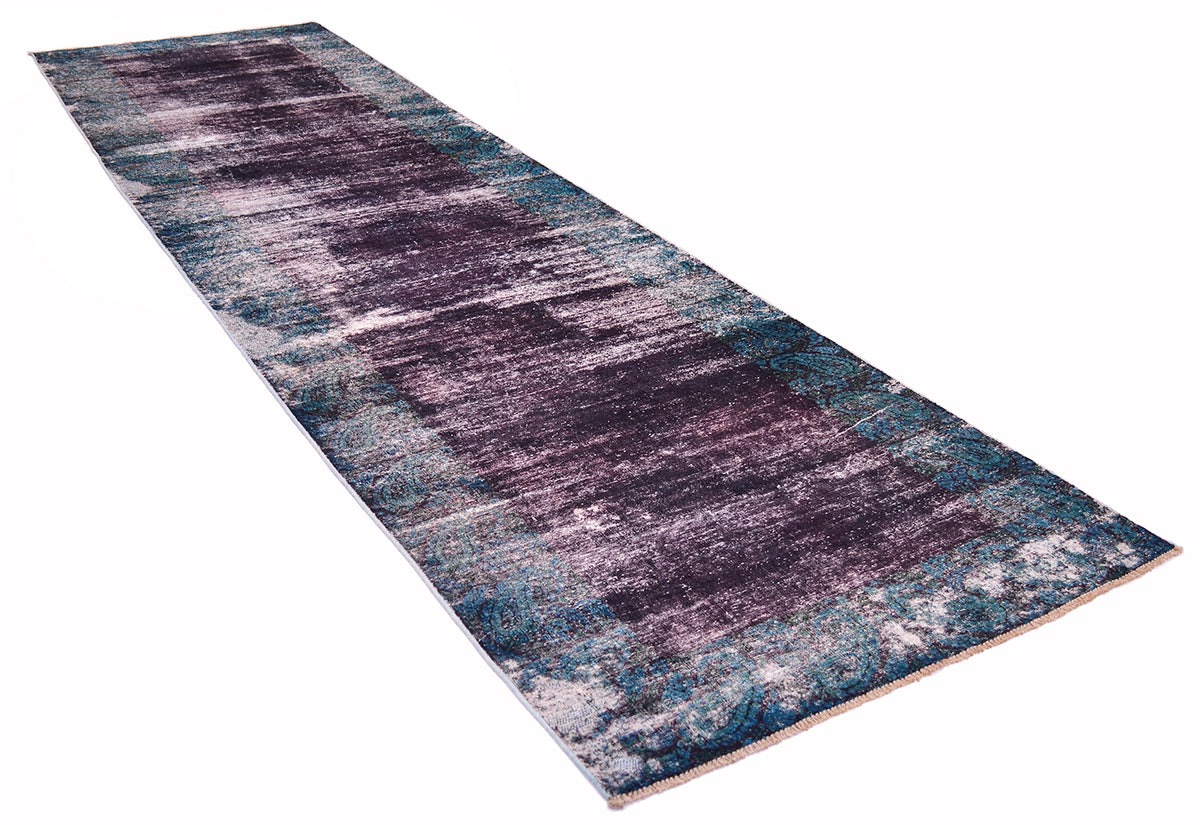 Angled view of hallway handmade vintage runner with distressed pile with aubergine coloured main field and border in peacock teal with patterning of traditional boteh paisley design.
