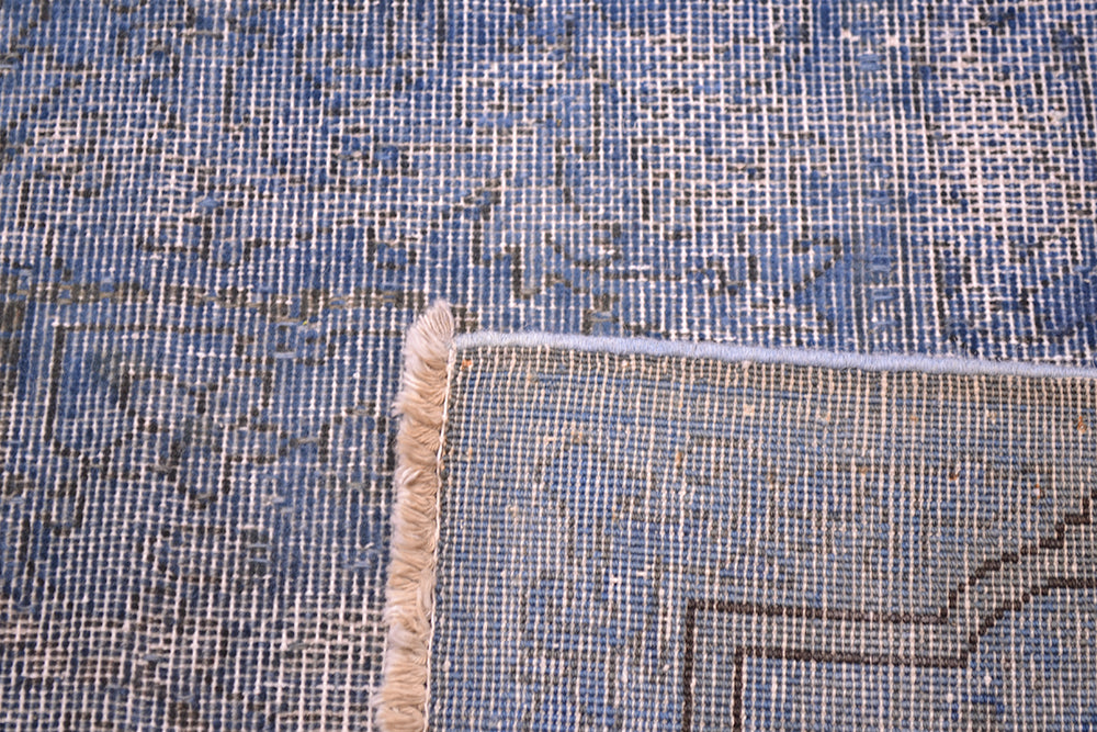 Reverse of vintage carpet with shaved  blue pile and dark charcoal detailing. Softened semi-floral geometric detailing.