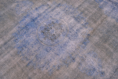 Floral medallion of blue and grey-brown overdyed carpet . Zero pile and warp and weft cotton foundation. vIntage caretps wioth traditional medallion design and overdyed. Circular medallion floral pattern.