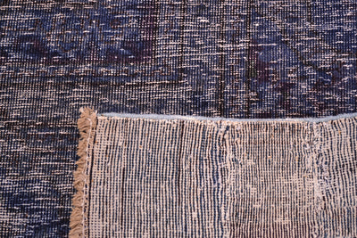 Back of  handmade and hadnknotted carpet showing cotton warps and wefts and back of knots. Deep blue indigo pile with low cut pile.