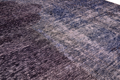 Close up and detail of main field of vintage carpet with zero pile and cotton warp and wefts. Shaved pile and re dyed with rich colouration of blue and aubergine.