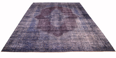 Overall view of vintage carpet in blue, indigo and aubergine on a white background. Fine knotting and vestiges of historical design and pattern. Rich colouration.