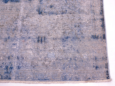 Detail of corner of overdyed carpet in blue and magenta fushia showing warp cotton threads and shaved distressed pile. Cotton warp foundation threads visible with cotton warp fringes. Areas of blue short pile in cobalt deep blue.