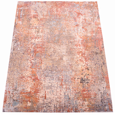 Overall view of modern expressionistic carpet with full wool pile and textured raised silk areas of ligth ble, light teal and terrattoa. Main base colours elements of charcoal, pewter grey, clays and stone tones.