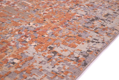 Detail of texture low and high pile of Indian handwoven carpet with raised high pile handcut silk construction with terracotta and bronze gold silk.