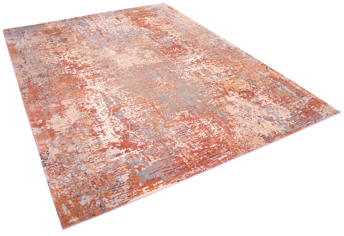 Angled view of modern abstract expressionistic carpet with earthy colours of light rusts and terracottas,  light silver blue, light gold bronze. light teal silk raised areas. Base colours of taupe andbeige and pewter greys.