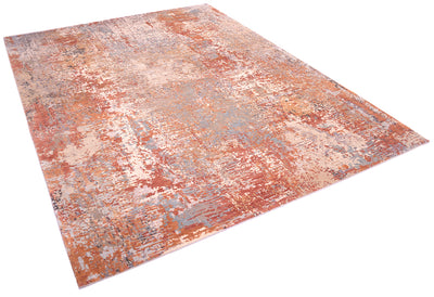 Angled view of modern abstract expressionistic carpet with earthy colours of light rusts and terracottas,  light silver blue, light gold bronze. light teal silk raised areas. Base colours of taupe andbeige and pewter greys.