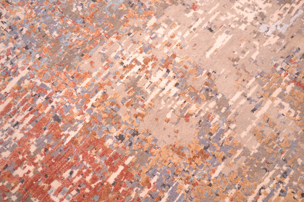 Close up view of detail of Indian modern carpet with wool colouors of taupe, grey and beige with raised silk highlights in gold-brone and terracotta.