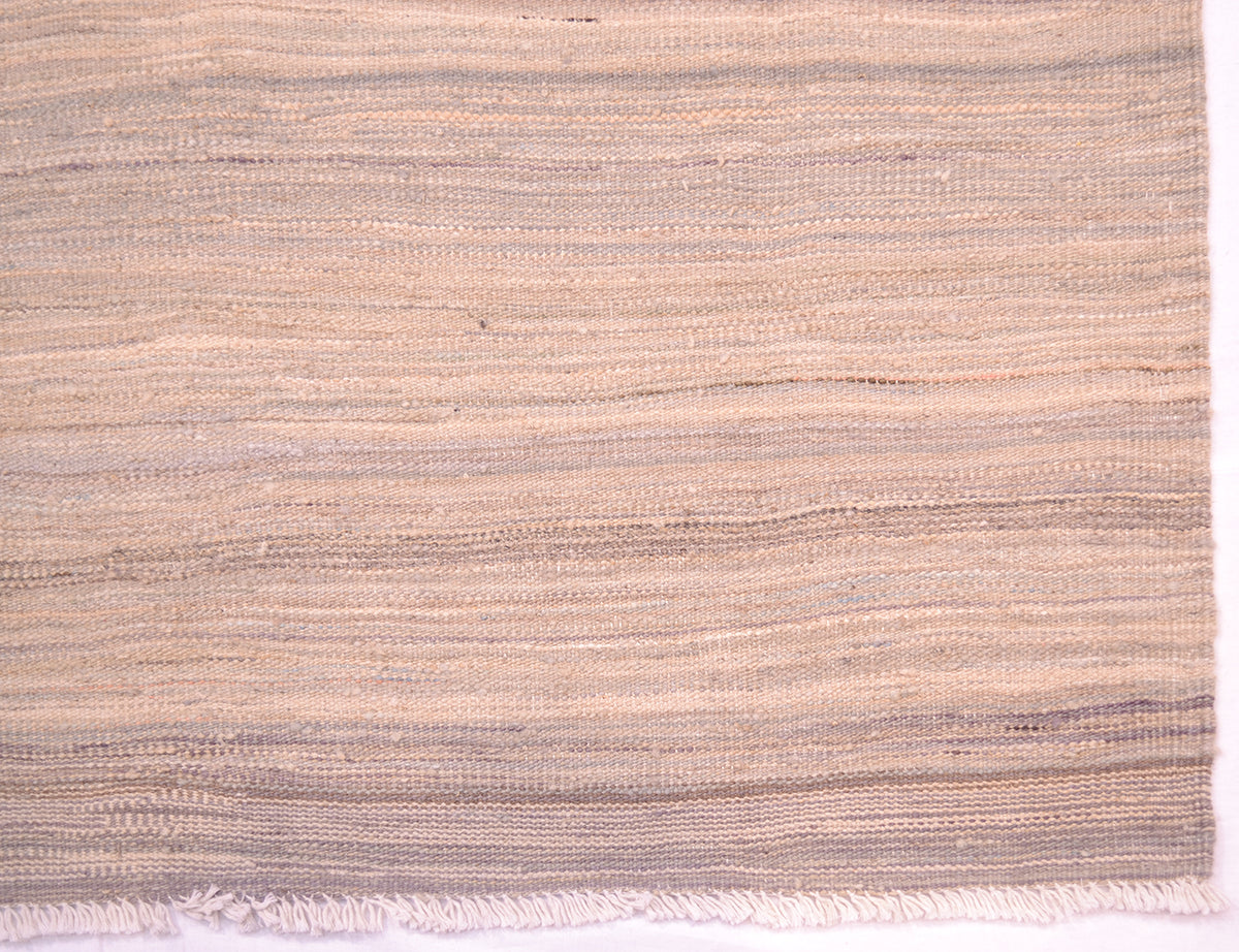 Detail of pastel abrash kilim with varying tones of blues, greys and creams with white cotton warp fringes.
