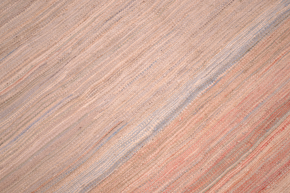  Detailed view of flatwoven kilim rug with subtle tones of pastel like colours; of pinks, light blues and grey greens. Handwoven in Afghanistan with natural dyes.