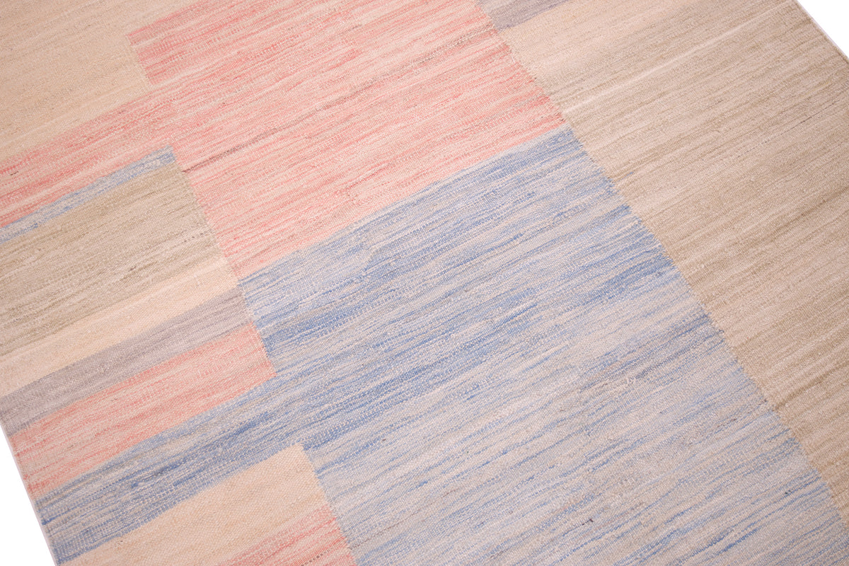 Close up detail of area of blue,pink and beige in handwoven flatweave kilim . Soft colours and pastel tones.