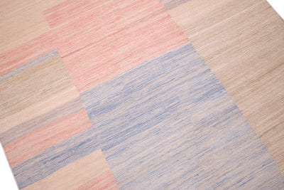 Close up detail of area of blue,pink and beige in handwoven flatweave kilim . Soft colours and pastel tones.