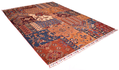 A 2x1.5m rectangular area rug with a complex patchwork design in rust orange, navy blue, and burgundy, featuring traditional geometric and floral motifs with fringed edges.