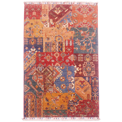 Hand-knotted wool pile Afghan Patchwork design rug with a mixed assortment of geometric patterns and colours including ochre, red, burnt orange, green, blue, and brown.