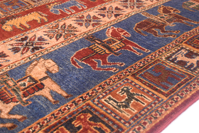 A close-up of a Handmade Afghan Pazyryk carpet featuring stylized animal motifs, including horses and dogs, in a blue field with rust red and beige borders.