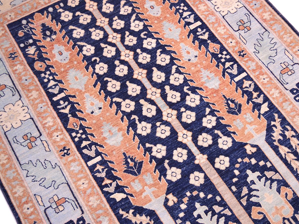 A close-up of a patterned hand-knotted Pictorial Afghan Bakshaish area rug featuring navy blue, rust, cream, and light blue with geometric and floral motifs.