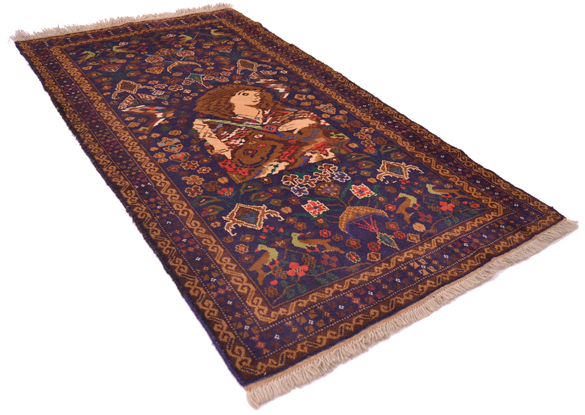 An old wool pictoral rug with a dark navy blue field, featuring a central figure in a red and gold robe, surrounded by floral motifs and a decorative border, finished with  fringe.
