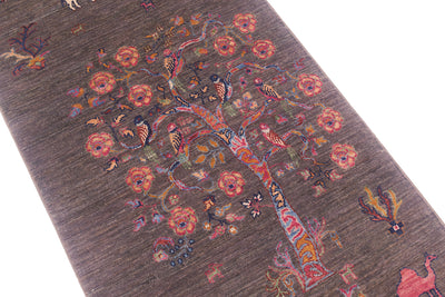 A close-up of a textured wool Pictorial grey Loribaft runner featuring a stylised tree of life motif in muted brown, pink, orange, and blue tones.