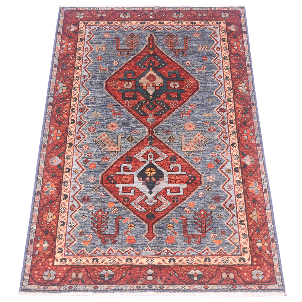 A traditional oriental Qashqai area rug with a red border, a blue field, and two large central diamond medallions in red, navy, beige, and orange.