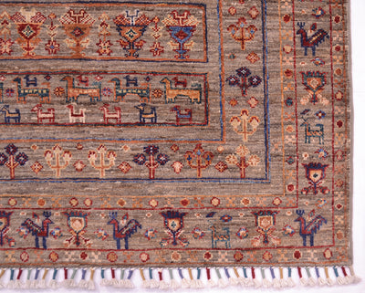 A close-up of a traditional handwoven modern Afghan Samarkand rug with a beige-gray base and multicolour geometric and animal motifs, finished with a fringed edge.