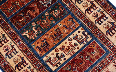 Patterned small rug with red, blue, and cream geometric motifs in bordered layout