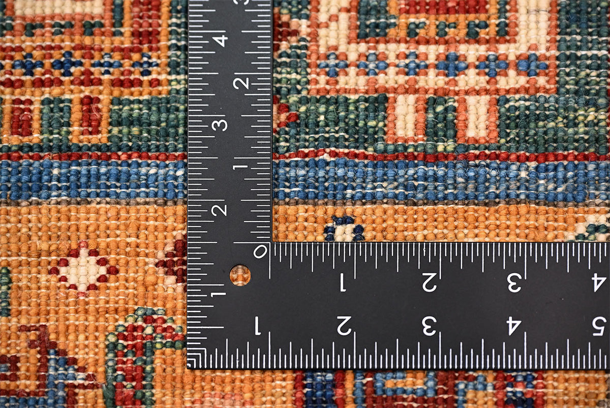 Rug weave close-up with measuring ruler across blue, orange, and cream pattern