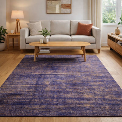 AI generated image: A rectangular Handmade Sari Silk area rug in a purple-blue and beige distressed pattern, shown in a modern living room setting with a light wood coffee table, beige sofa, and wooden flooring.