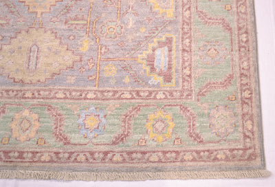 Corner of Afghan Serapi rug with soft green border with soft blue, yellow and red ornamentation. Woven on cotton warps.