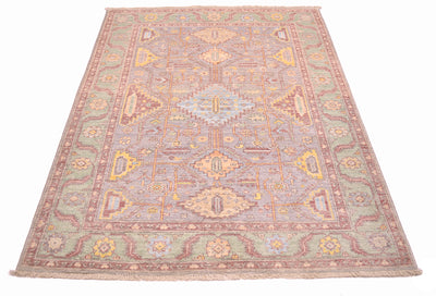 Detailed view of All over geometric design of Afghan Serapi Carpet with main field colours of light grey surrounded by a green border and soft red pink minor borders and stylized vines.
