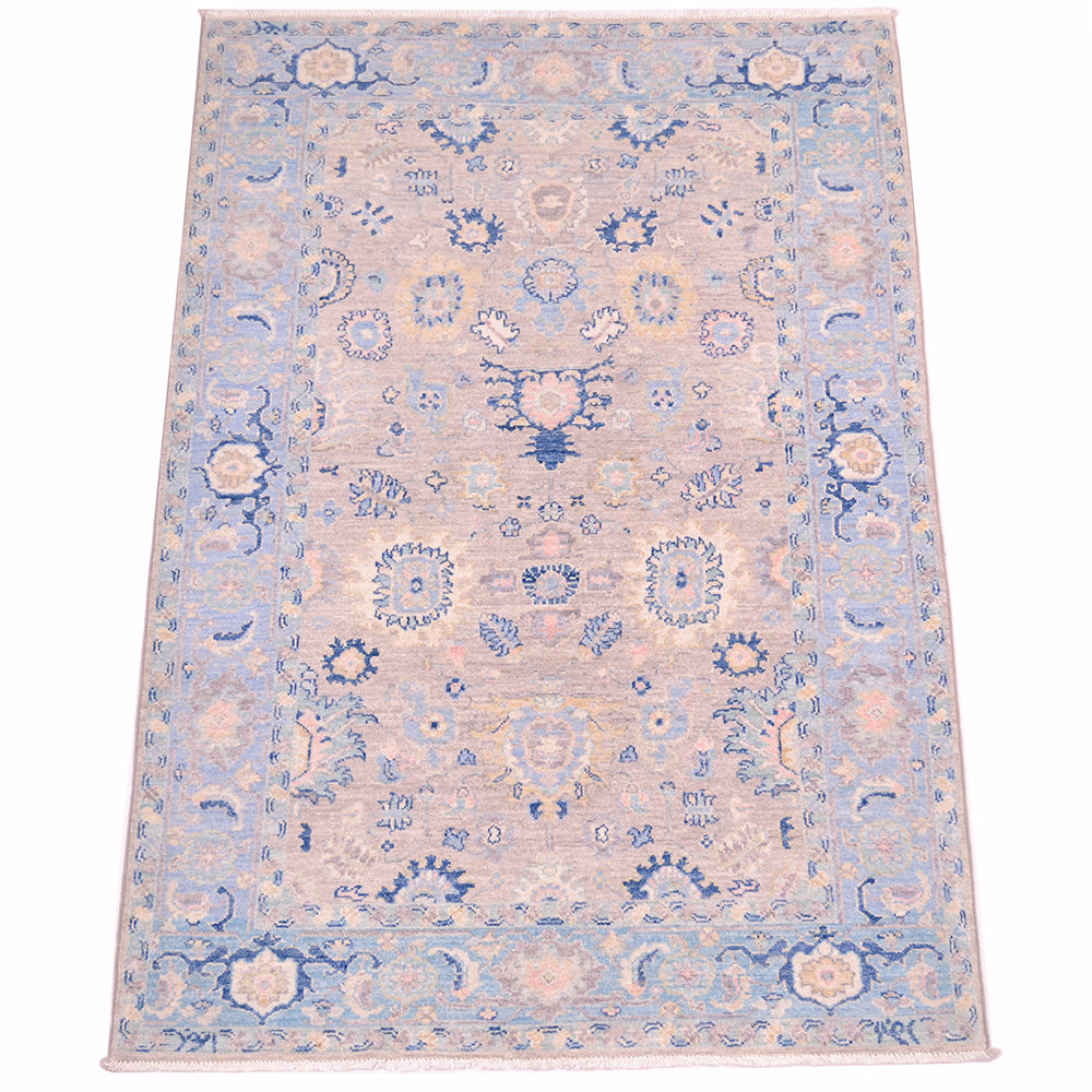 View of soft grey field of handmade Afghan Serapi Rug  with cloudband border with sfort light blue backgrouns, Additional colours include pink, duck- egg, cream, beige and yellow.