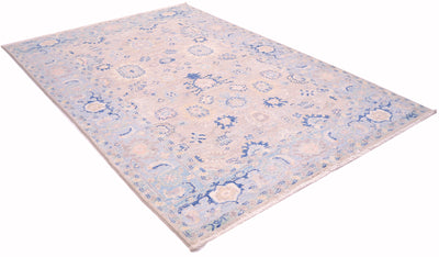 Angled view of handknotted serapi design carpet with deep blue outlinging and cloudband border with soft light grey field and pure wool pile. Rosettes and all over floral patterns.