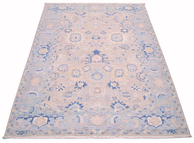 Handwoven rug inspired from designs of antique persian carpets with soft blues and greys and multiple floral motifs of rosettes and palmettes.