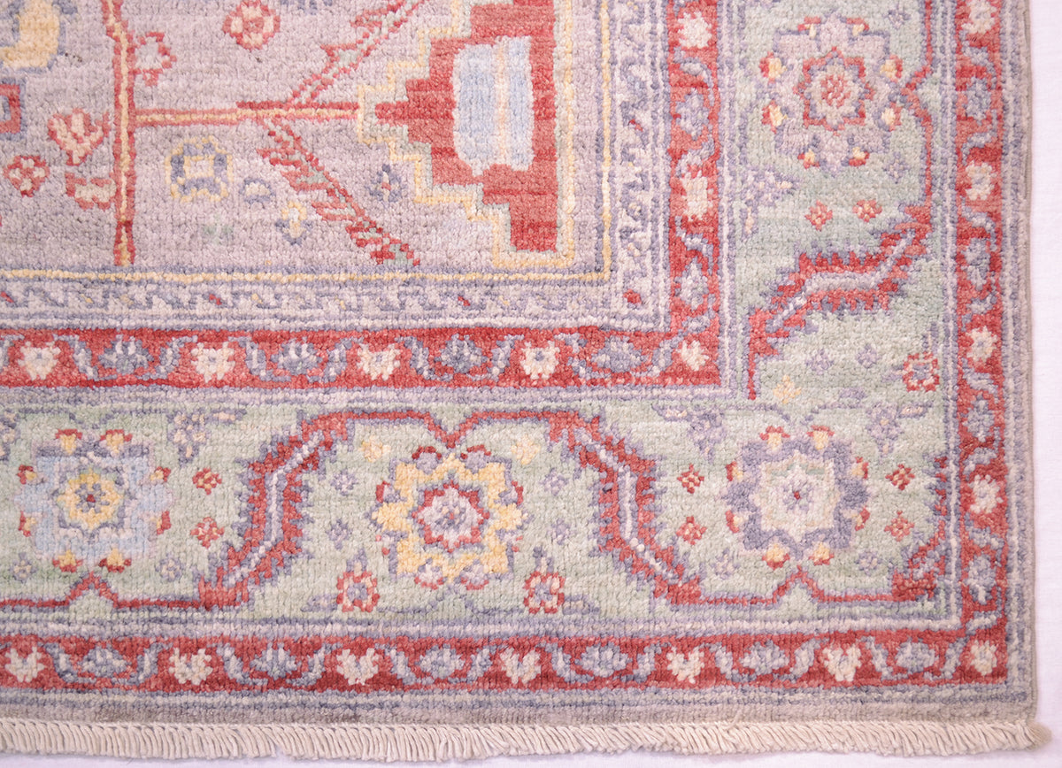 Corder detail of border of grey serapi rug with articluated serrated leaf and rosette border with pure wool pile woven on a cotton foundation. 