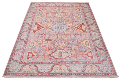 Geometricised floral motifs typify this handmade Afghan Serapi design rug with main field colour of soft grey with elemetns of yellow gold, soft green , light blue and light rust reds.