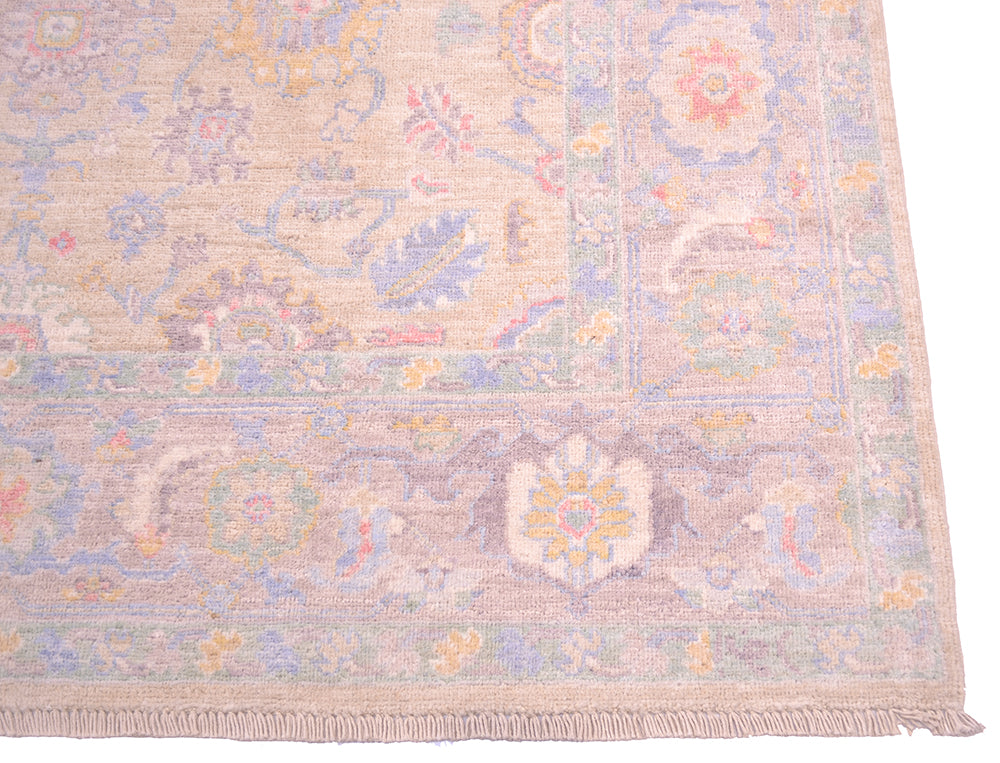 Corner detail of handmade rug from Afghanistant with elegant motifs in soft colours and traditional antique Serapi floral design.