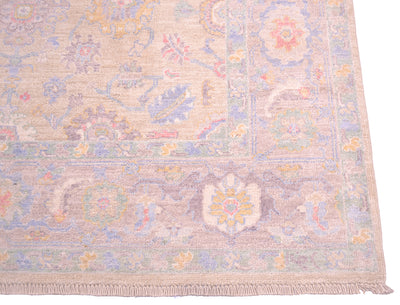 Corner detail of handmade rug from Afghanistant with elegant motifs in soft colours and traditional antique Serapi floral design.