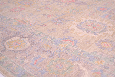 Close up image of border and field of handknotted rug with soft pleasing colours and cloudband border design with a soft grey/mauve background. 