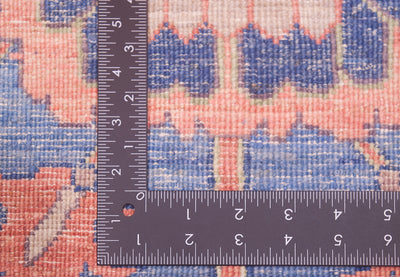 Reverse of runner rug showing knotting and variety of pleasing hues in  coral pink, blue and cream. 