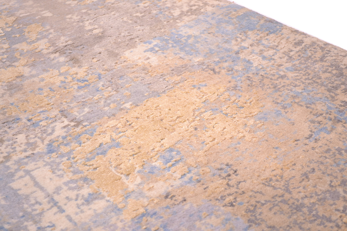 Detailed view of textured carpet with blue and grey and cream matte background of wool pile wirh golden cream pure silk raised highlights.Soft colours and durable pile.