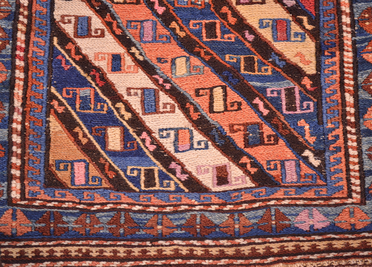 Antique khorjin rug close-up of diagonal geometric stripes in blue, rust, and cream