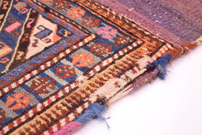 Antique khorjin rug edge view with fringed border and blue geometric medallions