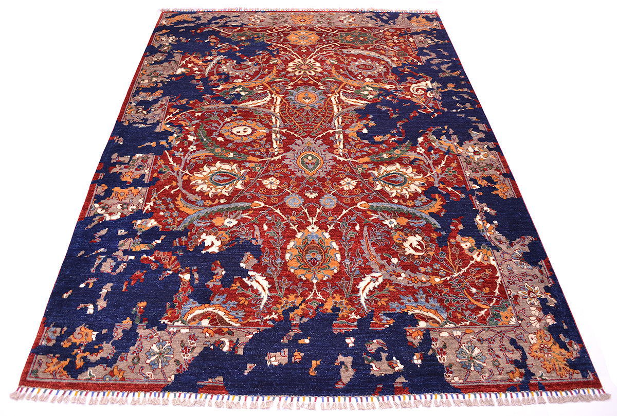 A traditional oriental area rug with an intricate floral and medallion pattern, featuring a deep navy blue field, red and orange central motifs, and cream and beige accents, finished with white fringe on the bottom edge.