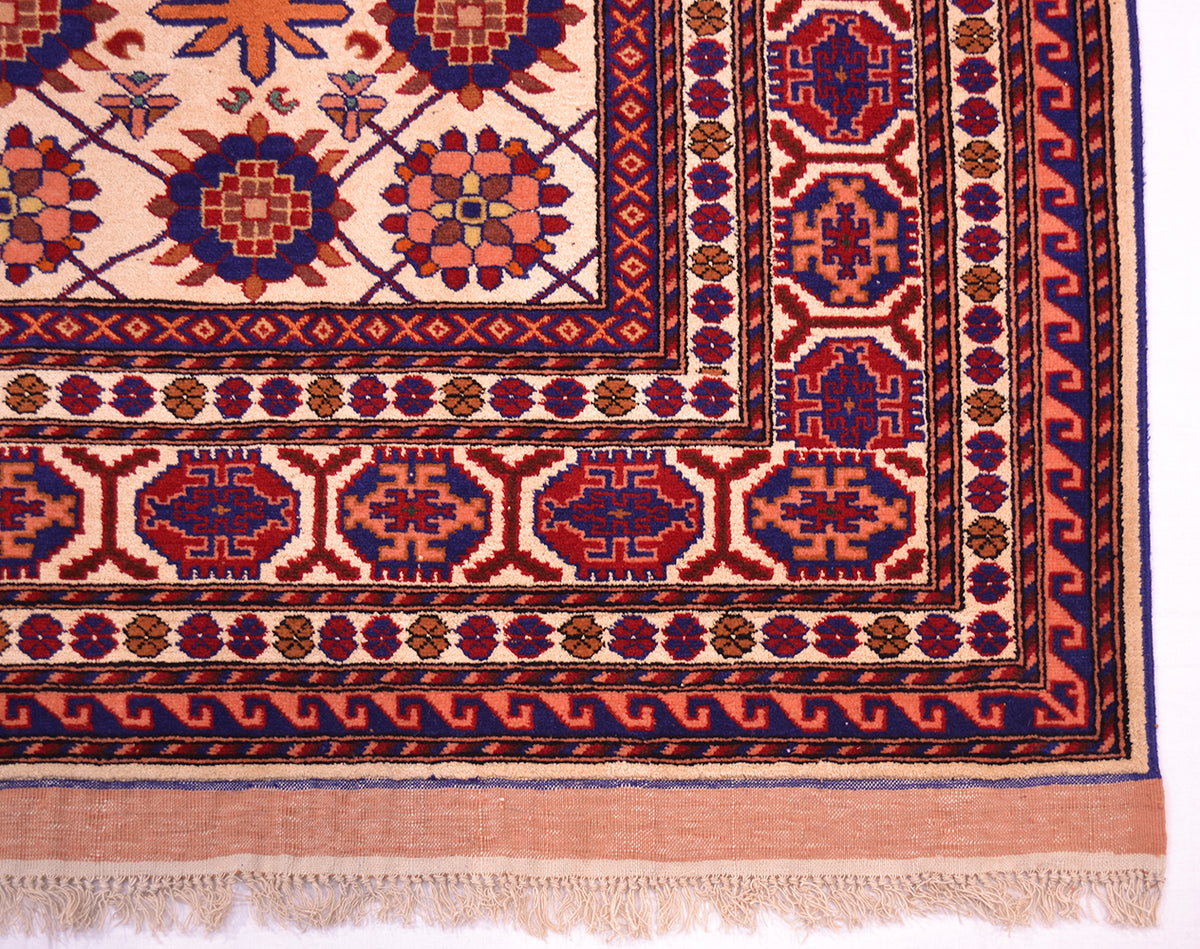 Kabul silk and wool rug corner detail with red medallions, blue accents, and fringed edge