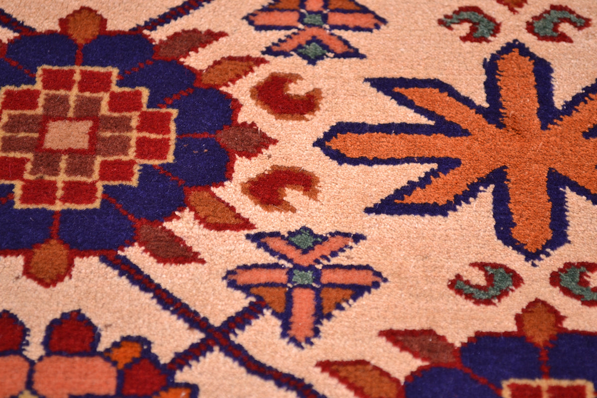 Close-up of Kabul silk and wool rug motif: cream field with orange, red, and blue shapes