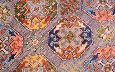 Detail view of Ersari guls of fil pai design Sultani rug with secondary guls of eight-pointed stars and starflowers. Colours of tan, rust red, coral pinks, greens, gold and blues.
