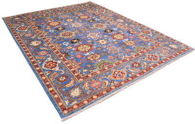 Angled view of Sultanabad rug on a white background showing glorious colours of red and blue with multiple secondary colours. All over floral field with famaous Persian design; handwoven in Afghanistan. 
