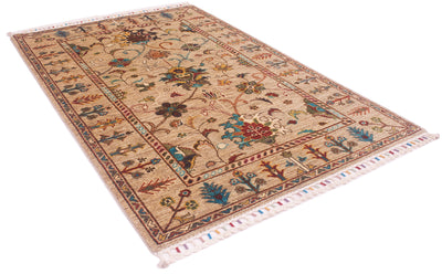 Angled view of all over floral design of handknotted rug with pops of a variety of turquoise, greens, rusts and reds. Artistically bound warp threads to make up a fringe with colourful bindings.