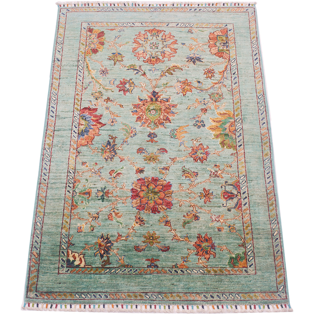 Highly floral main field of Afgha Handmade rug wity flowing floral filled field and more understated border.  Field colour of topaz green-aqua and rust and ambers of main decorative field.