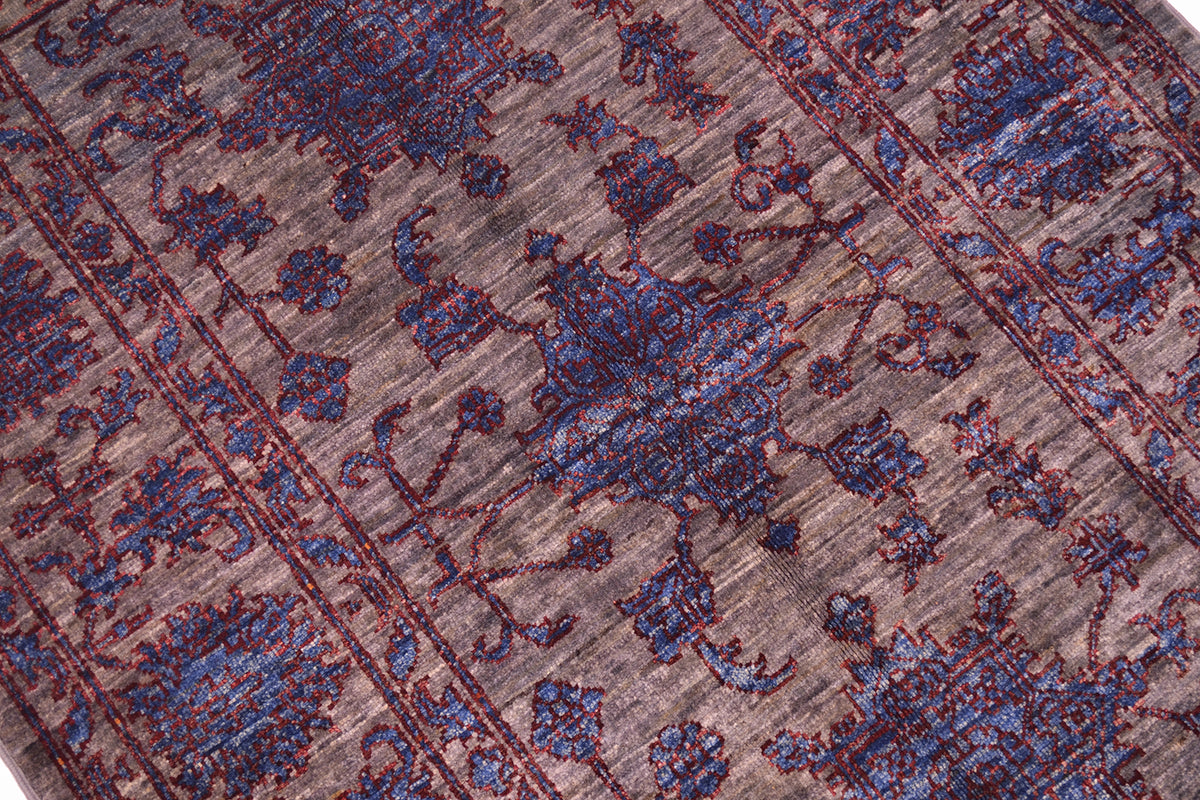 Detail and close up of main field og Afghan Sultaini rug with rich blue detalign of motifs, grey neutral main back ground colour and  rich chestnut red defining outlines punctuating the design.